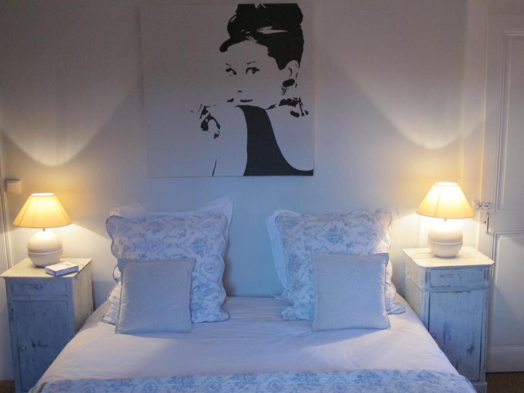 トノン・レ・バンにあるLe Clos Des Fontainesのベッドルーム1室(ランプ2つ、壁に絵付)