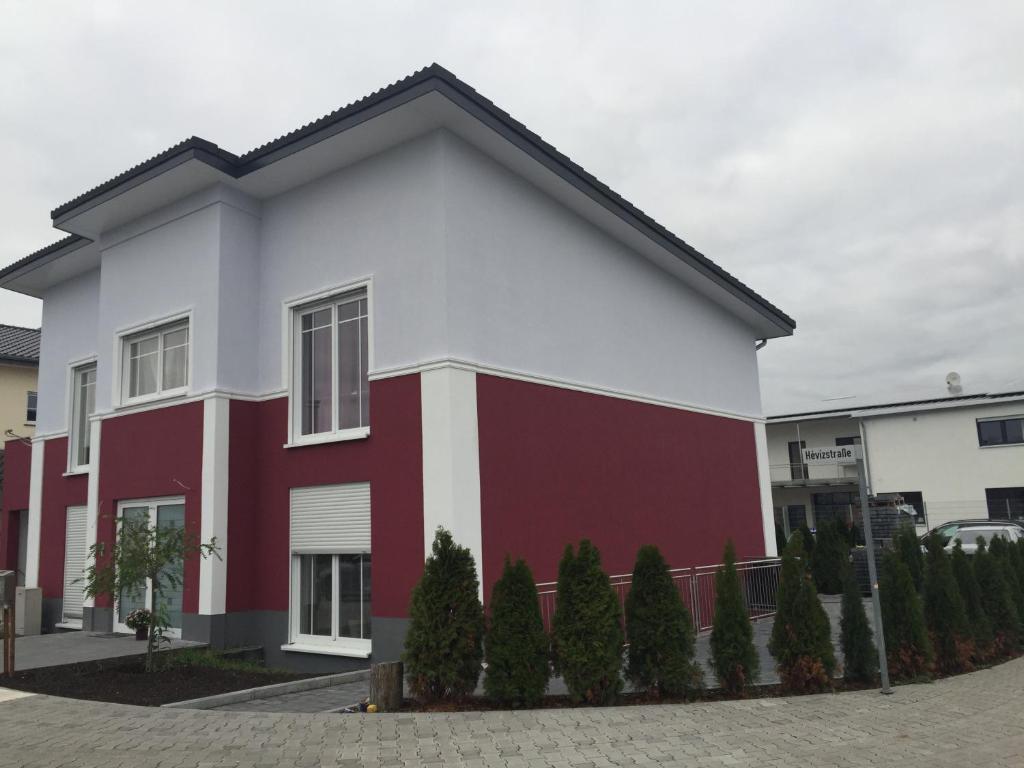 a red and white building with trees in front of it at Appartements Funk in Pfungstadt