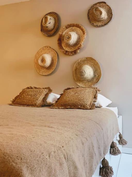 - une chambre dotée d'un lit avec des paniers sur le mur dans l'établissement Charmante maison de ville 2 chambres avec terrasse, très calme, à Marseillan