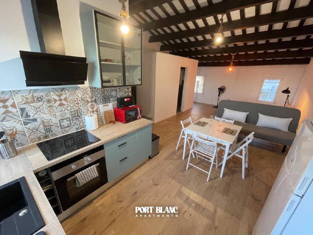 a kitchen and living room with a table and a couch at PortBlanc Apartments - 4 in Arenys de Mar