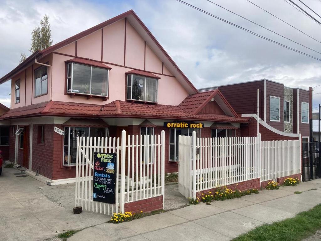 una casa rosa con una staccionata bianca di erratic rock a Puerto Natales