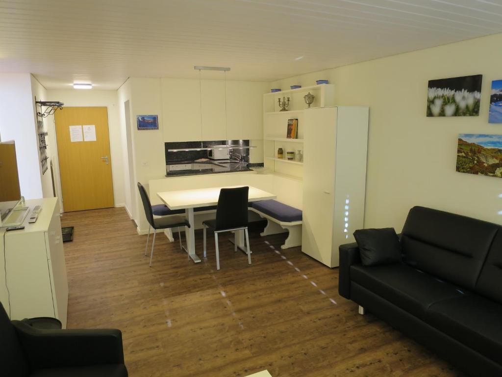 アローザにあるVilla Franca E06のテーブルと椅子、キッチンが備わる客室です。