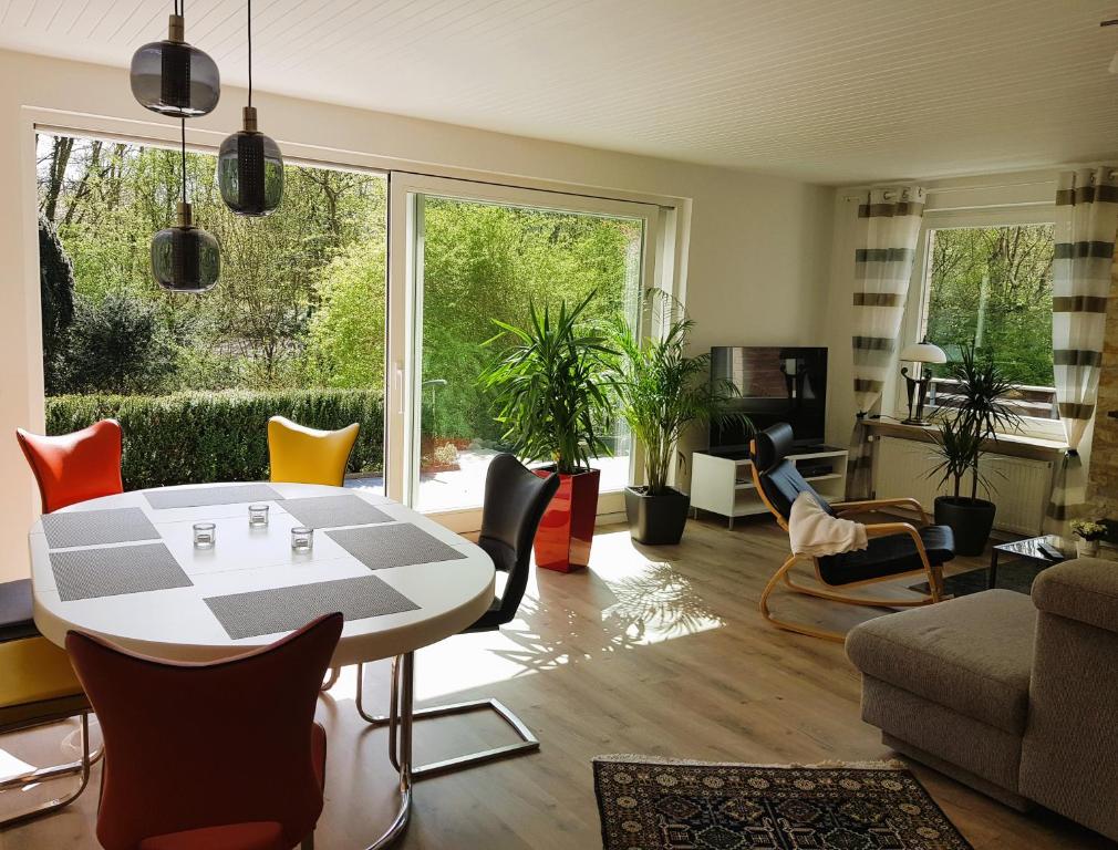 a living room with a table and chairs at Schöne 120-qm-Ferienwohnung - Sonnenterrasse - Stadtgrenze Lübeck in Stockelsdorf