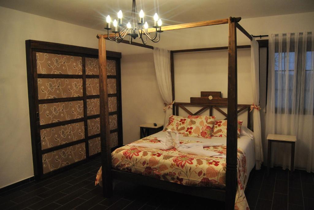 ein Schlafzimmer mit einem Himmelbett und einem Kronleuchter in der Unterkunft Villa El Valle in Tarajalejo