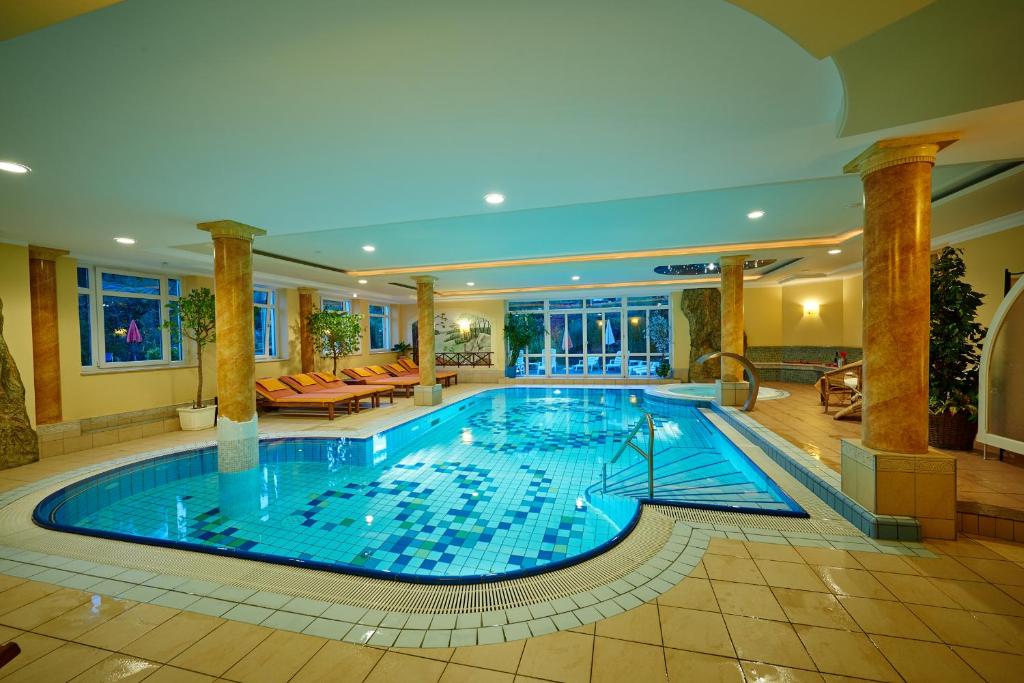 a large swimming pool in a large room with at Hotel Brunnenhof in Bayerisch Eisenstein