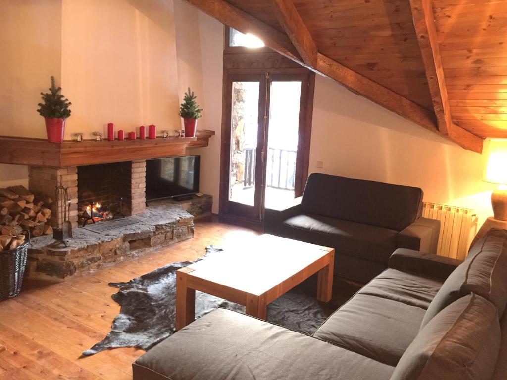 sala de estar con sofá y chimenea en Ski Andorra Tarter Chalet Lodge, en El Tarter