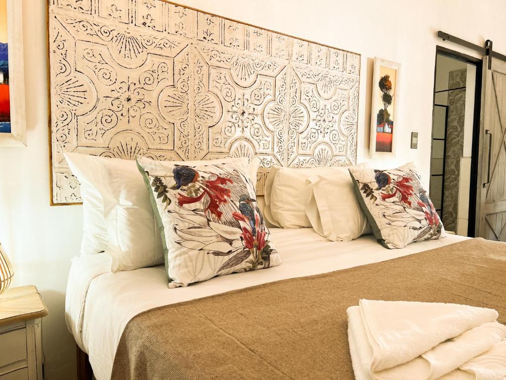 a bedroom with a bed with pillows on it at The Lux Guesthouse in Kroonstad
