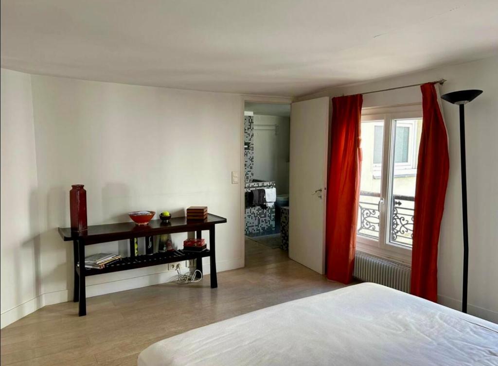 une chambre avec un lit, une table et une fenêtre dans l'établissement Paris Montorgueil, à Paris