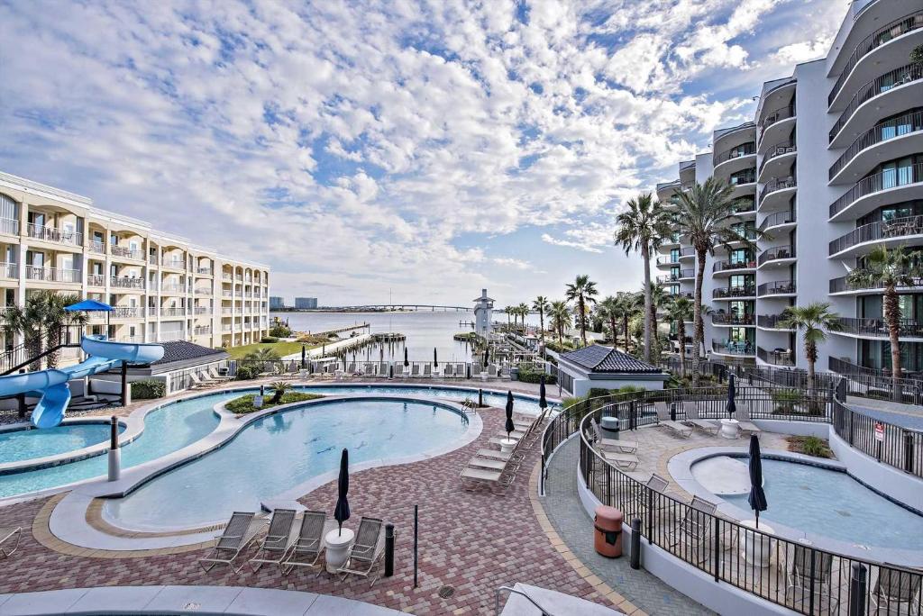 a resort pool with a view of the water and buildings at Phoenix on the Bay II 2212 in Orange Beach