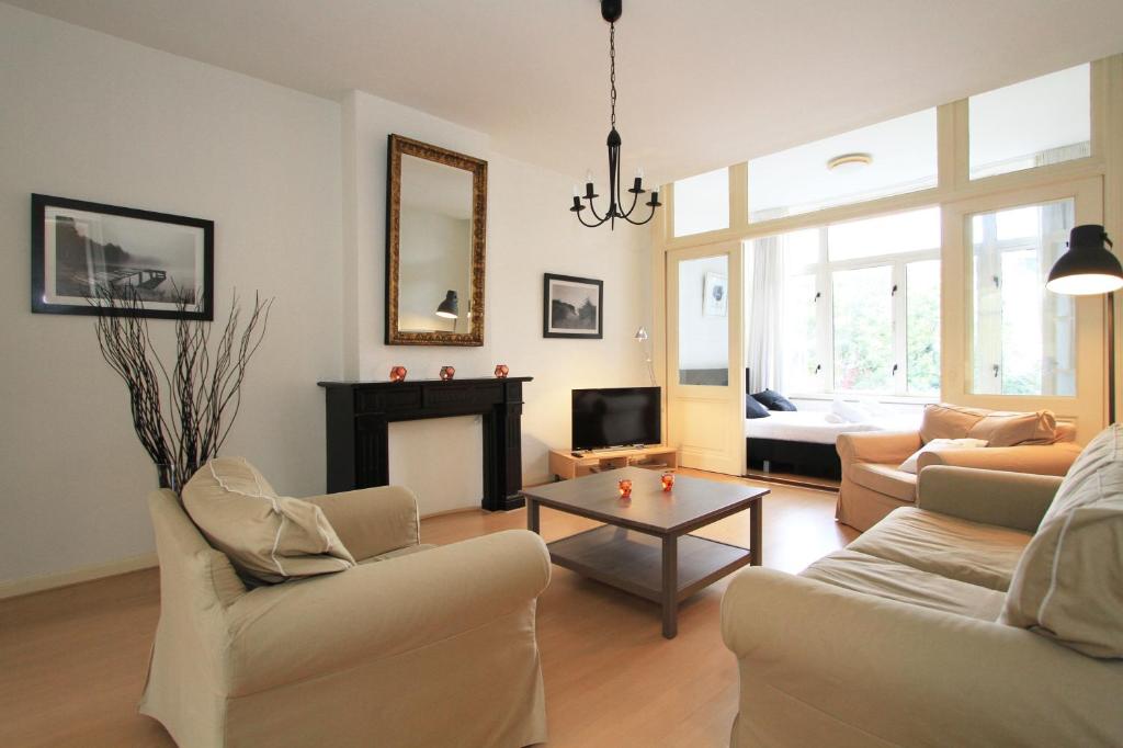 a living room with white furniture and a fireplace at Nassau Canal Apartments in Amsterdam