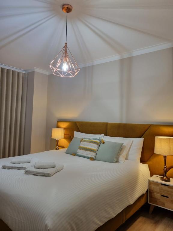 une chambre avec un grand lit blanc avec deux lampes dans l'établissement Diamante house com garagem privada, à Braga