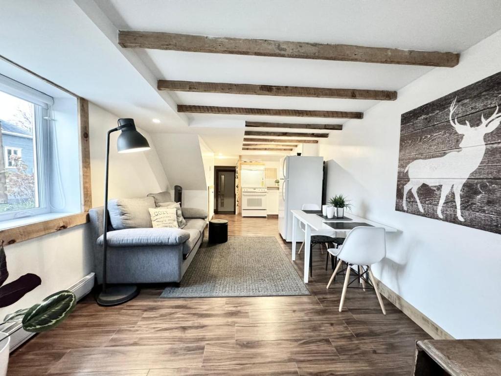 a living room with a couch and a table at Le Montcalm Chutes-Montmorency in Boischâtel