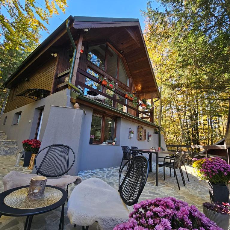 a house with chairs and tables and flowers in front of it at Wild House in Sinaia