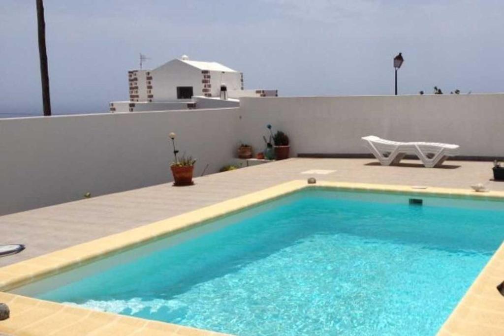 a swimming pool on the roof of a house at Can Blum in La Asomada