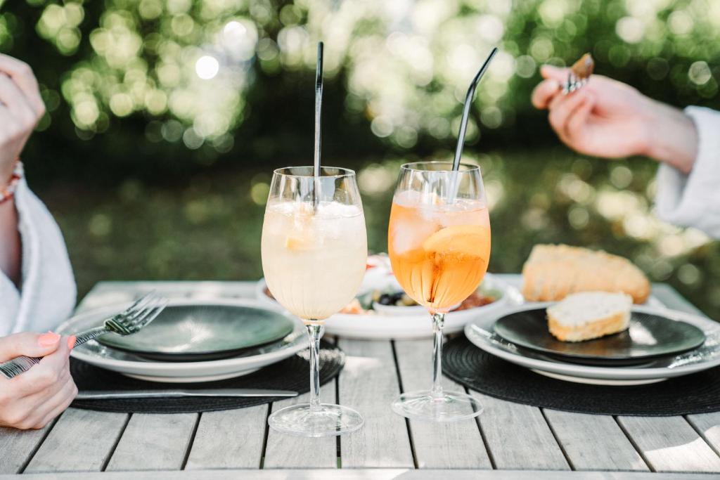 a table with two wine glasses and plates of food at Céleste Beauté & Spa in Nalinnes