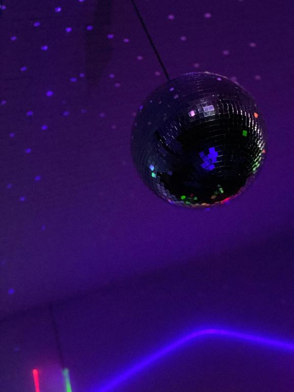 - une boule de disco suspendue à un plafond violet dans l'établissement Propriété, lac, plages privées IDF 77 proche Paris, à La Tombe