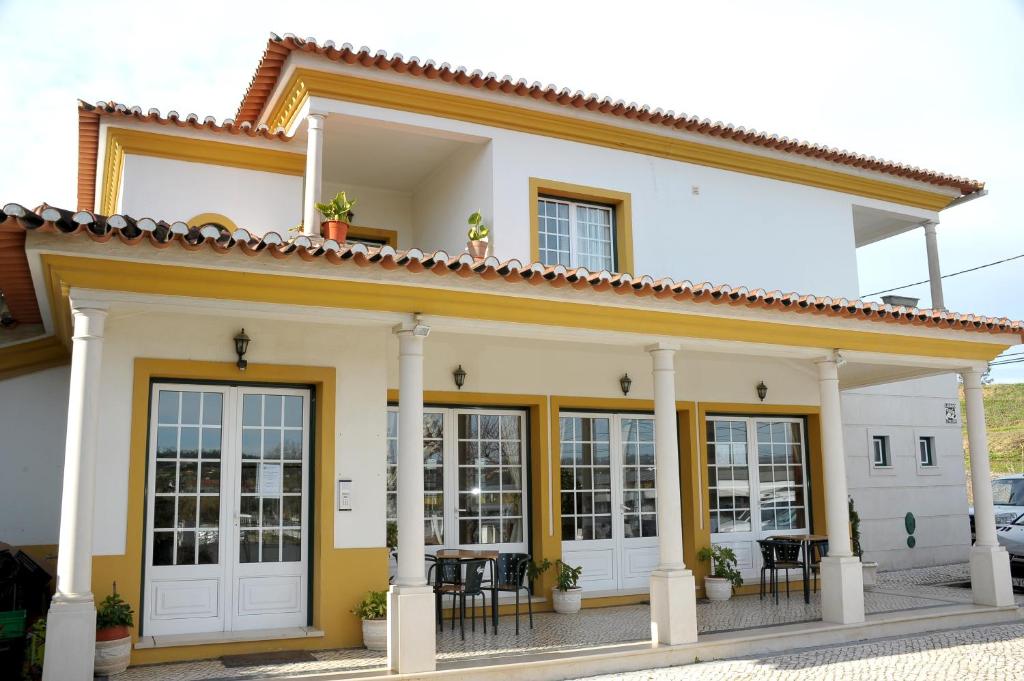 a white house with columns and windows at Ninho do Falcao in Sao Pedro de Tomar