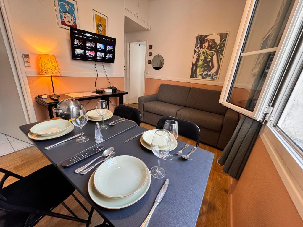 une salle à manger avec une table avec des assiettes et des verres à vin dans l'établissement Peaceful Flat w WiFi Very Close to Pl Massena Refurbished, à Nice