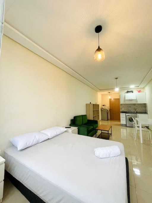 a bedroom with a white bed and a kitchen at Studio confortable in Tangier