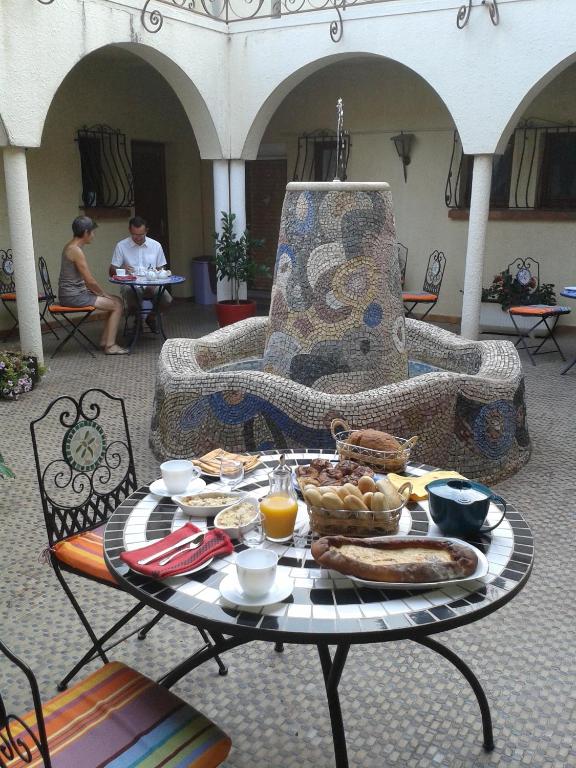 a table with a tray of food on a patio at Chambres d&#39;hôtes et gîtes Al Pati in Sorède