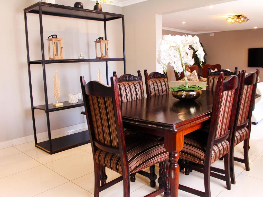 a dining room with a wooden table and chairs at The Bethel House in KwaDabeka
