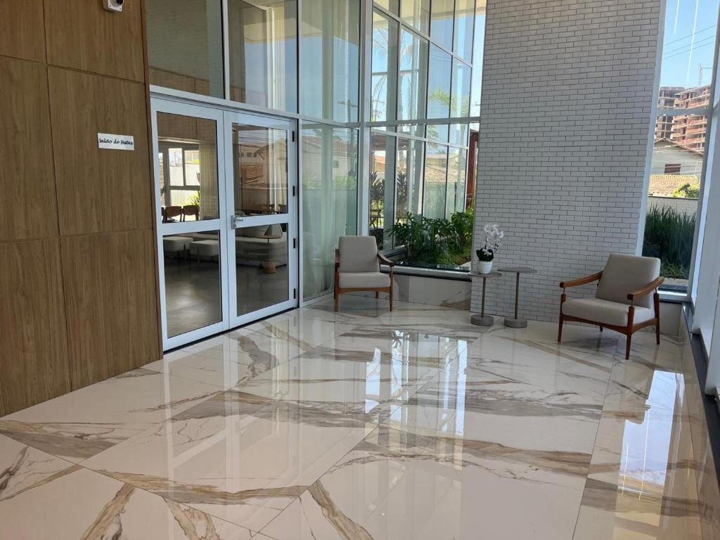 eine Lobby mit Stühlen und einem Tisch in einem Gebäude in der Unterkunft Apto de ferias em Bertioga Maitinga in Bertioga
