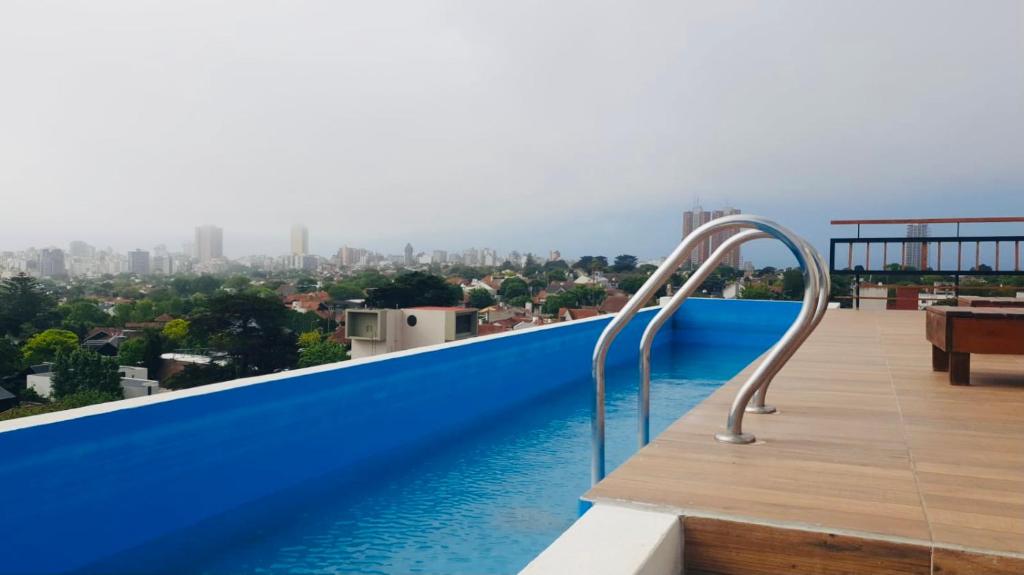 a swimming pool on the roof of a building with a city at EG12 Playa Grande in Mar del Plata