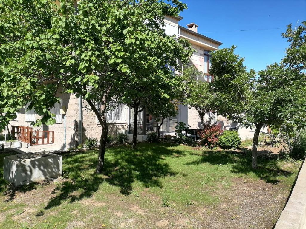 a house with a yard with trees in front of it at Kapadokya Tatil Evi in Urgup