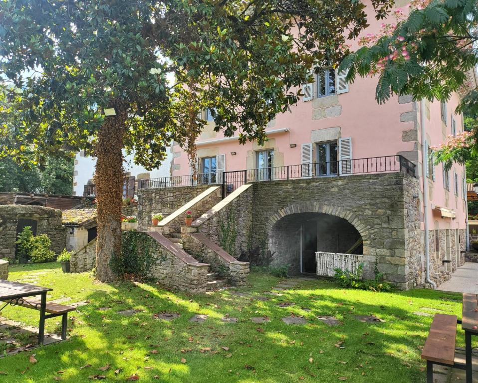 a pink building with stairs in a park at Tresanea Apartamentos in Ituren