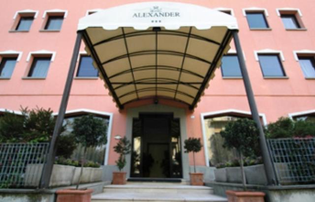 a pink building with an awning in front of it at Hotel Alexander in Fiorano Modenese