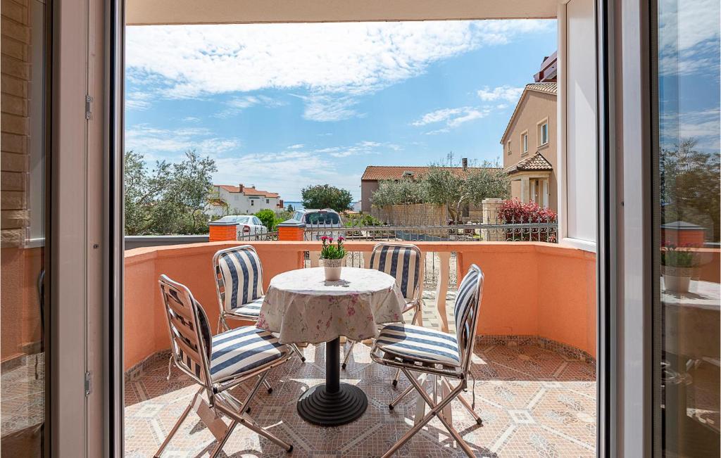 un patio con tavolo e sedie su un balcone di Holiday Apartment Betiga 04 a Barbariga
