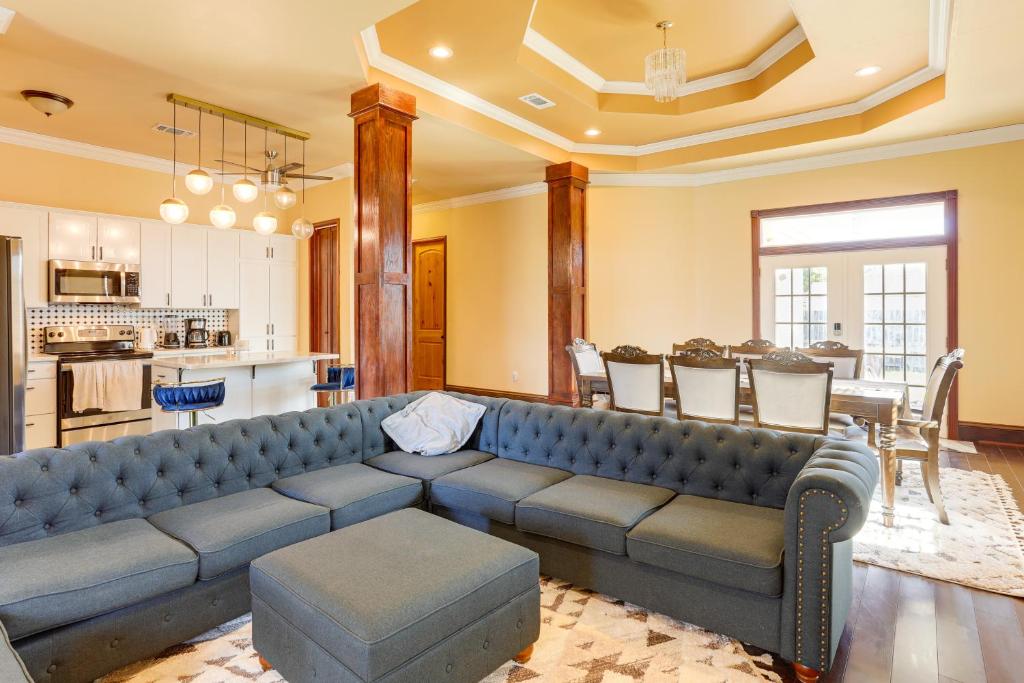 a living room with a blue couch and a kitchen at 8 Mi to French Quarter Home with Patio and Yard in New Orleans
