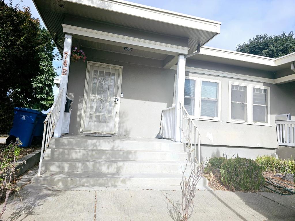 a white house with stairs leading to a door at Cozy Craftman Cottage in Quiet Historic Vallejo Neighborhood in Vallejo