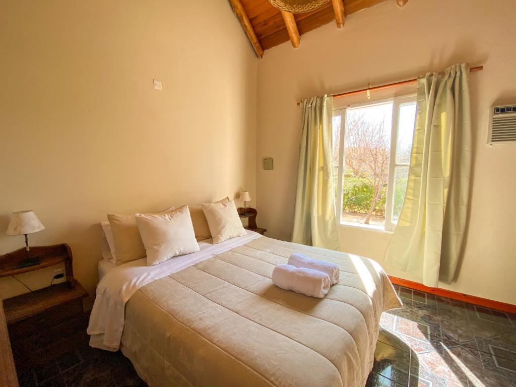 a bedroom with a large bed with a window at El Solar Casas de Campo 3 in Valle Grande