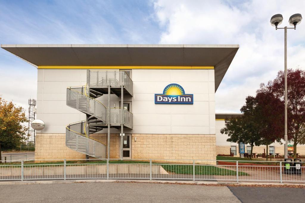 a large building with a clock on the side of it at Days Inn Hotel Leicester in Leicester