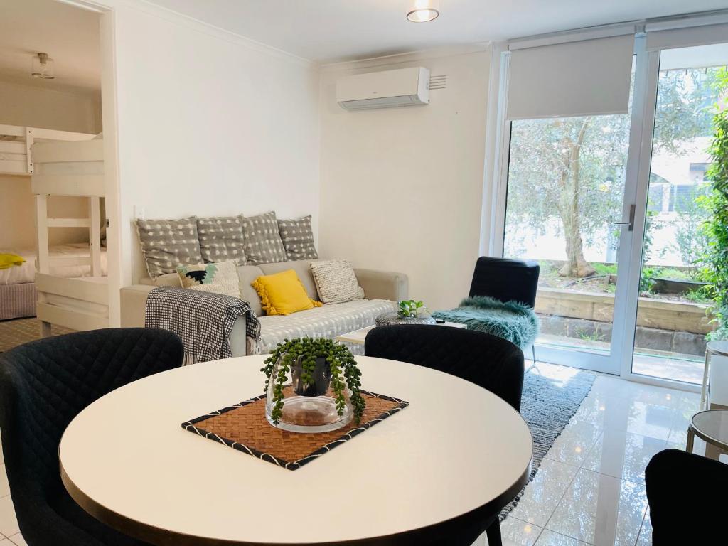 een woonkamer met een witte tafel en stoelen bij D101 Charming Apartment- Free Parking in Melbourne