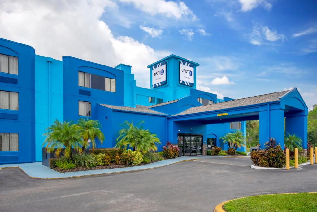 un hotel azul con estacionamiento en SPOT X Hotel Tampa - Wesley Chapel by The Red Collection, en Wesley Chapel