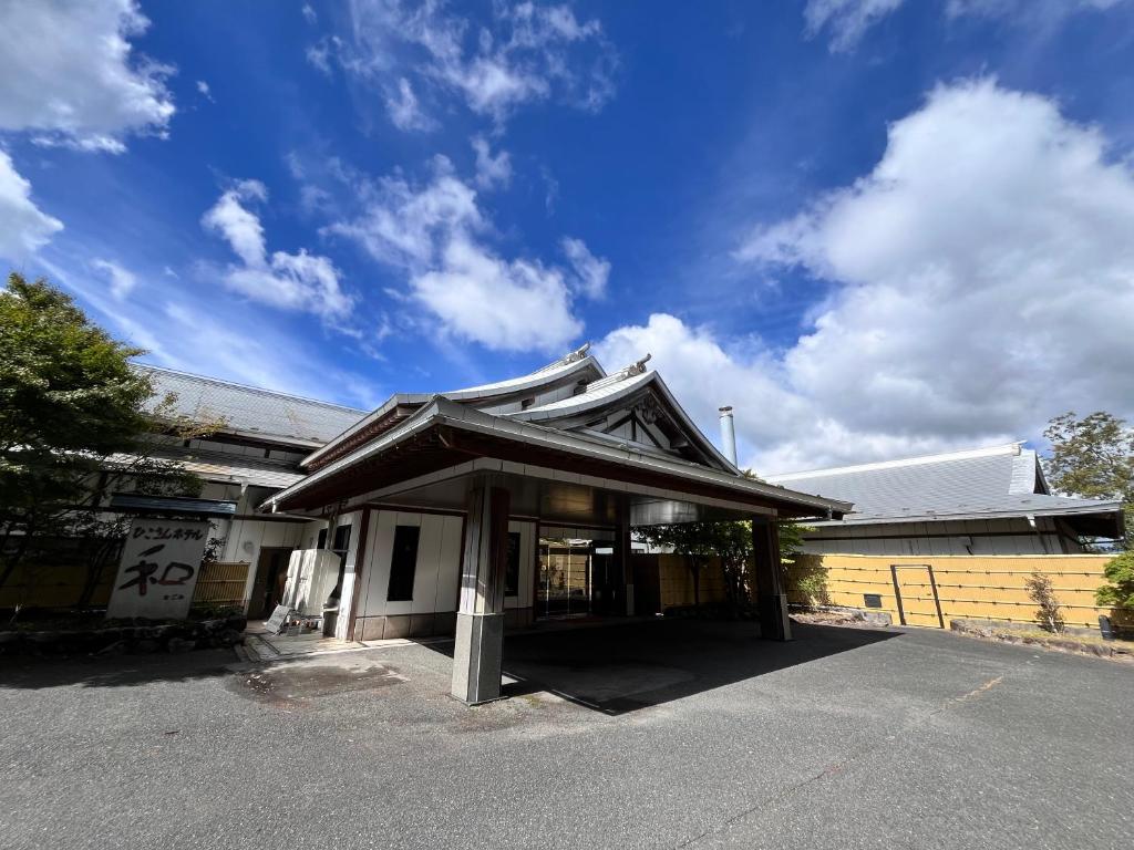 a building with a japanese roof on a street at ひこさんホテル和 in Hikosan