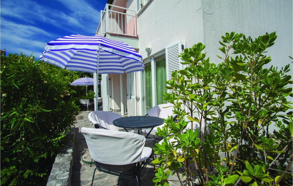 patio ze stołem, krzesłami i parasolem w obiekcie Awesome Apartment In Baska With Wifi w Bašce