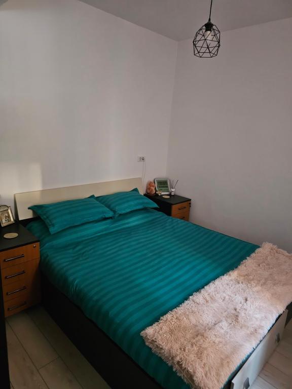 a bedroom with a bed with a green comforter at Luxury 1 Bedroom Apartment in Roşu
