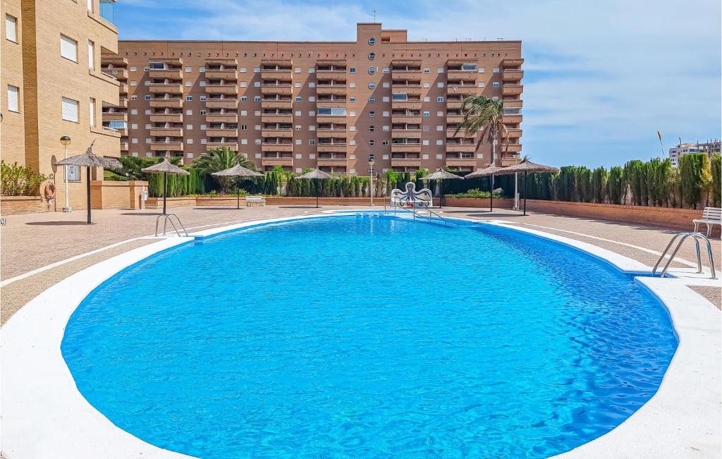 ein großer blauer Swimmingpool vor einem Gebäude in der Unterkunft 2 Bedroom Gorgeous Apartment In Oropesa in El Borseral
