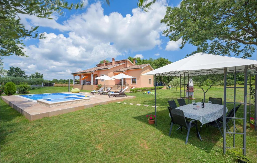 podwórko ze stołem i parasolem w obiekcie Two-Bedroom Holiday Home In Tinjan w mieście Tinjan