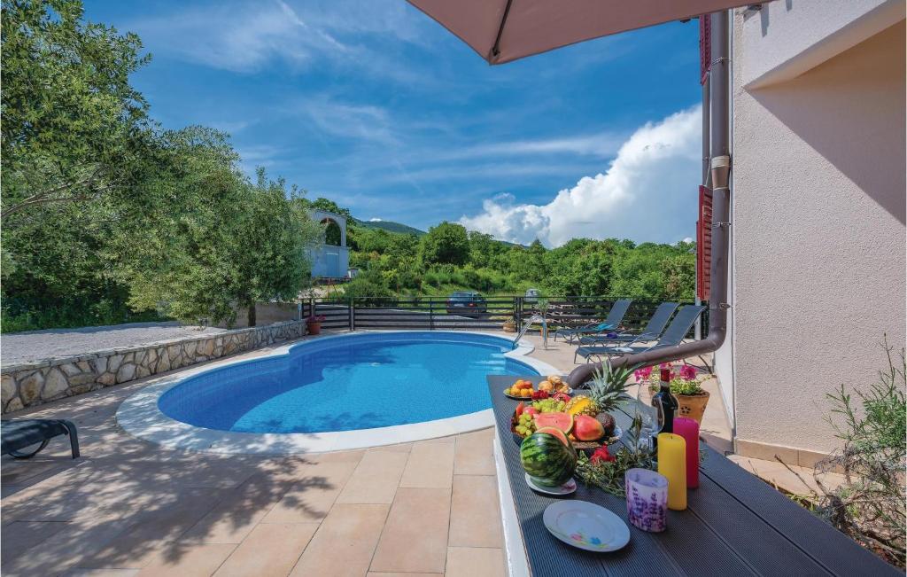 Willa z basenem i stołem z warzywami w obiekcie 2 Bedroom Beautiful Apartment In Labin w mieście Drenje