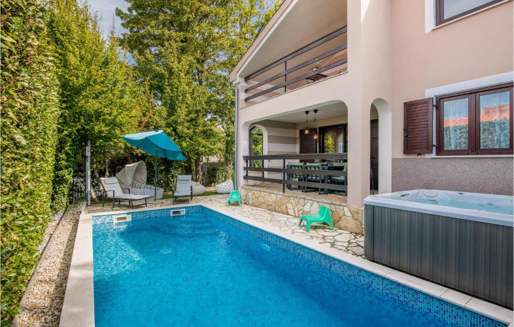 a swimming pool in the backyard of a house at Nice Home In Njivice With Wifi in Njivice