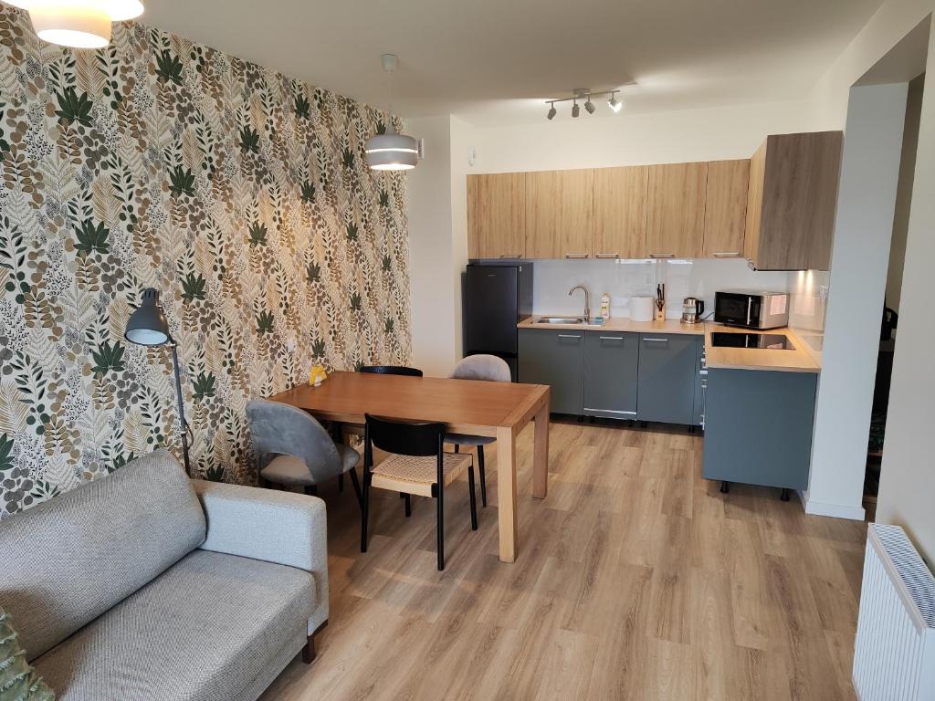 a living room with a table and a kitchen at Apartamenty MM - Nowa Sól in Nowa Sól