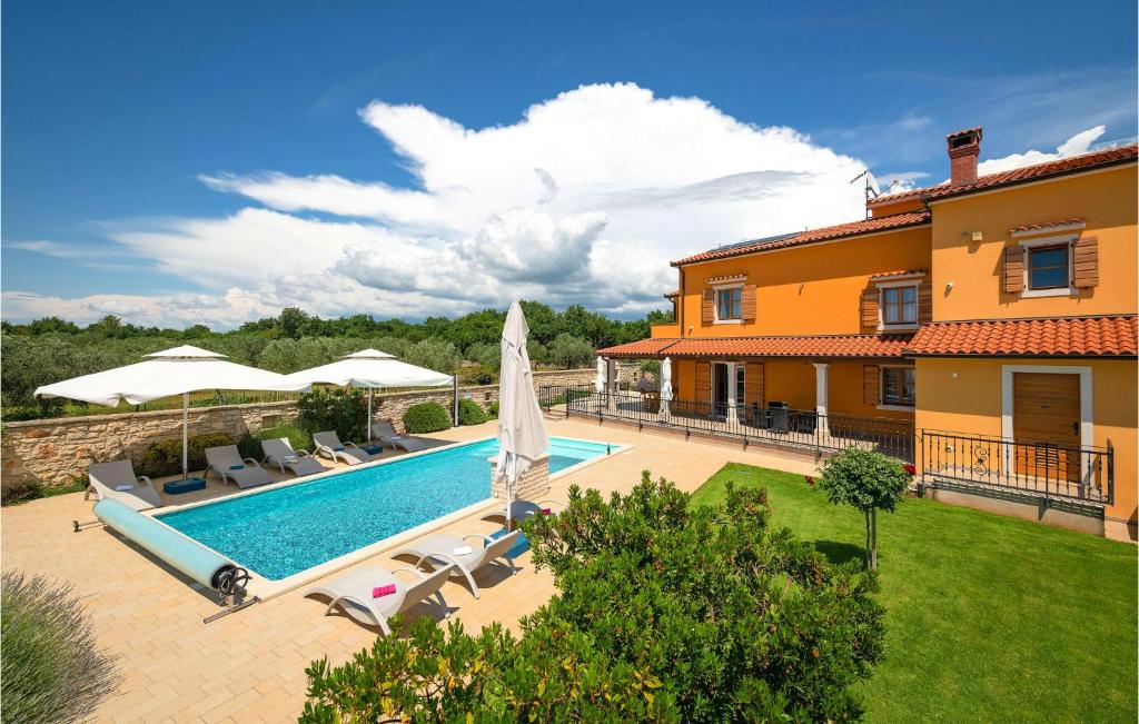 a swimming pool in front of a house at Nice Home In Hr-52215 Vodnjan in Vodnjan