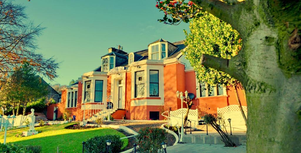 a large orange house with a tree in front of it at Tayview Hotel in Dundee