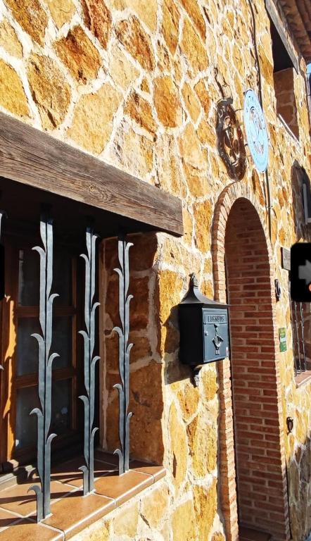 a stone building with a clock on the side of it at GREDOS RURALRUT en El Tiemblo a solo 1 hora de Madrid, descuentos agosto y septiembre, zonas de baño y ocio a pocos metros, Reservas Naturales, cabina hidromasaje, Aire Acondicionado, WIFI incluido in El Tiemblo