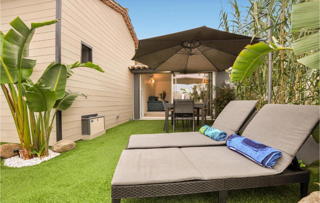 un patio avec une table et un parasol dans l'établissement Awesome Home In Cavalaire-Sur-Mer, à Cavalaire-sur-Mer