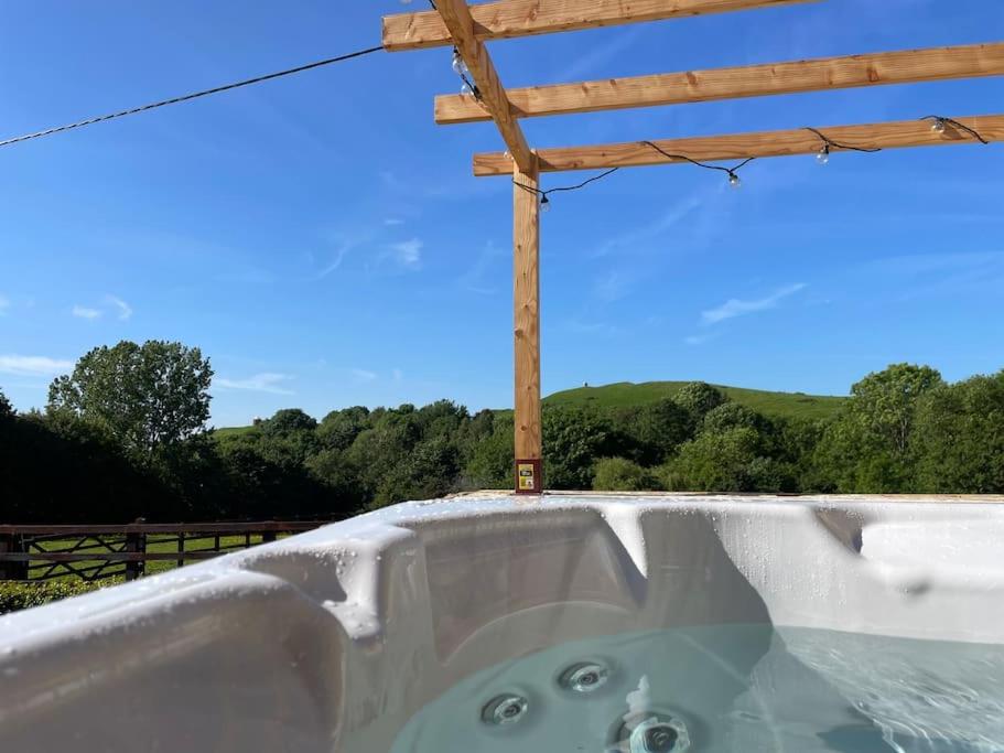 a bath tub with a wooden pole on top of it at Luxury cottage with Hot Tub in Fenny Compton